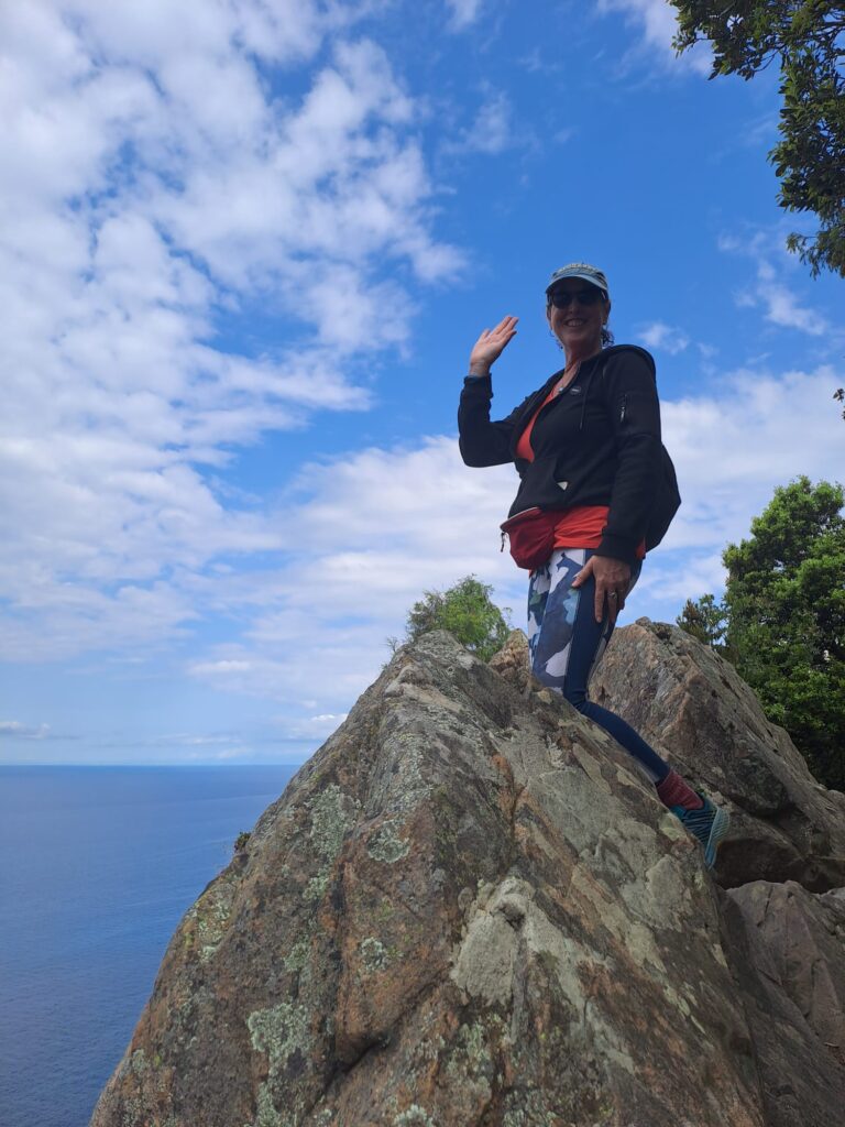 Woman standing on a rock overlooking the Mediterranean Sea — symbolizing courage, mindset exploration, and finding new paths.